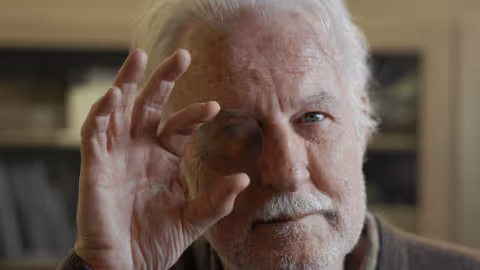Man holds a silicon wafer over his eye