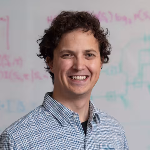 Simon Sponberg smiling in front of a whiteboard.