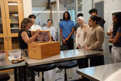 Woman demonstrates parts of a bee hive.